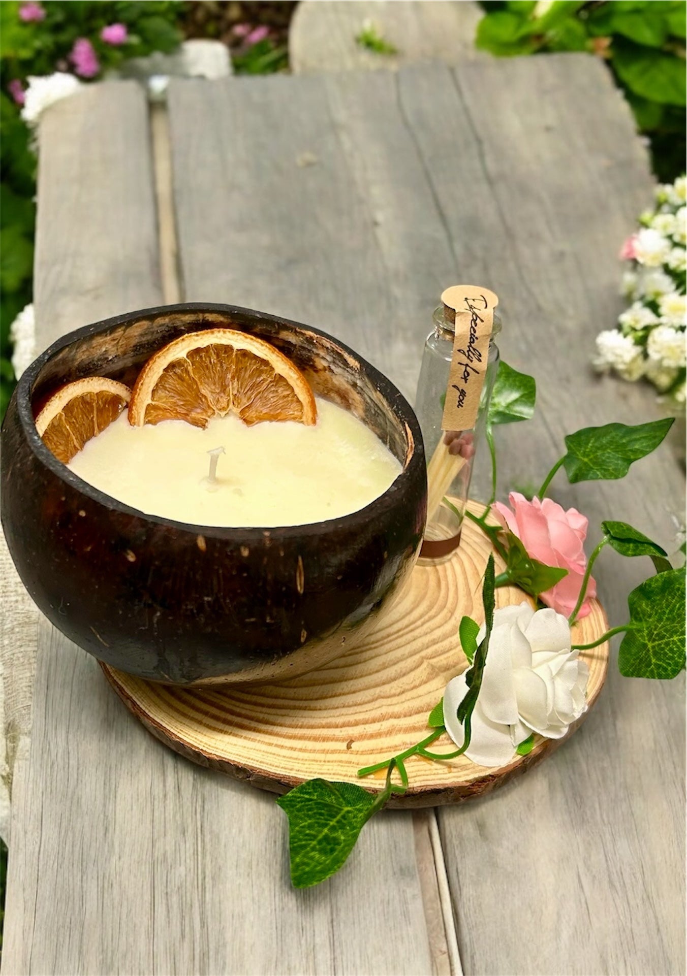 ORANGE Scented Coco shell candle with wooden slice and bottle of matches.