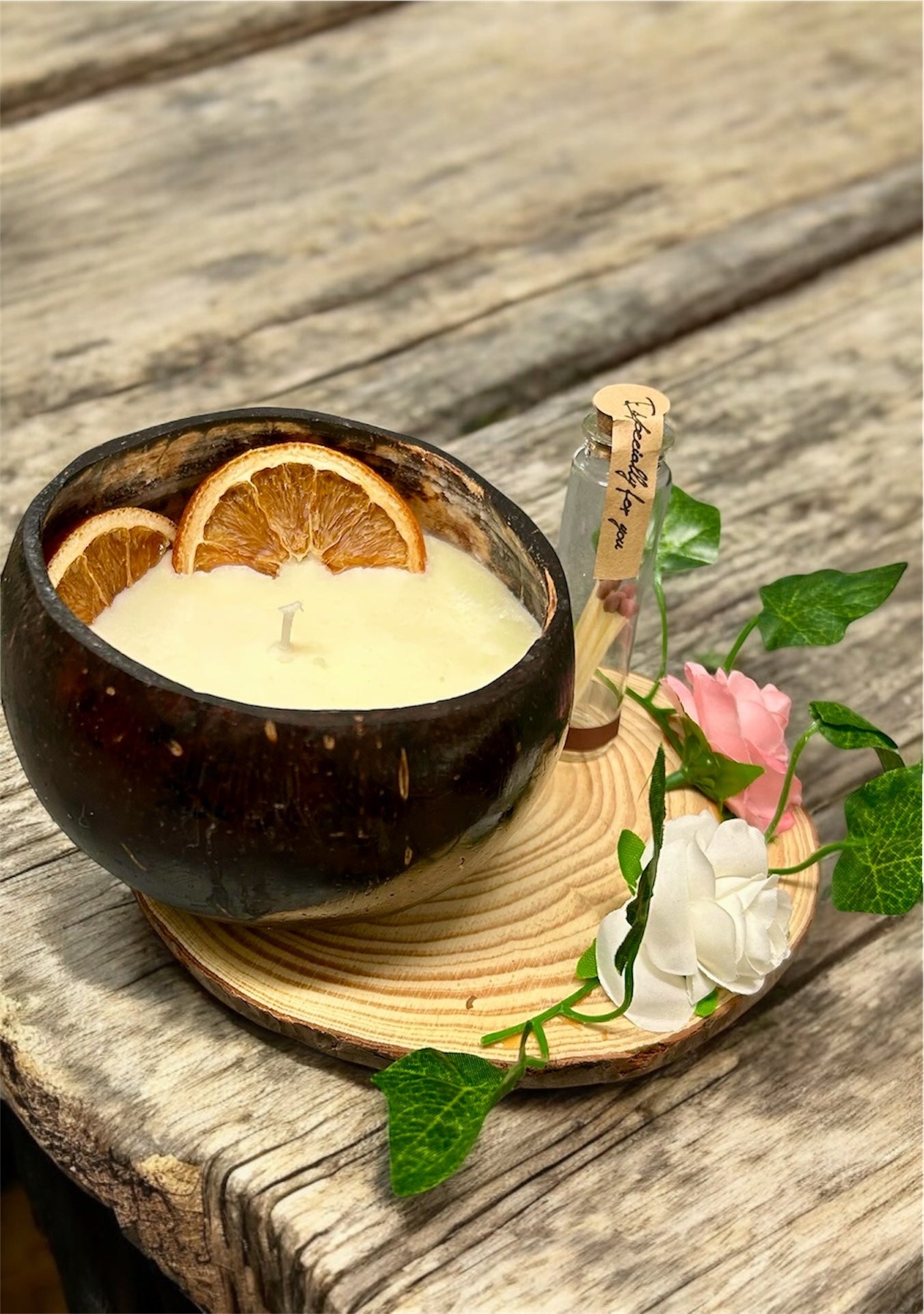 ORANGE Scented Coco shell candle with wooden slice and bottle of matches.