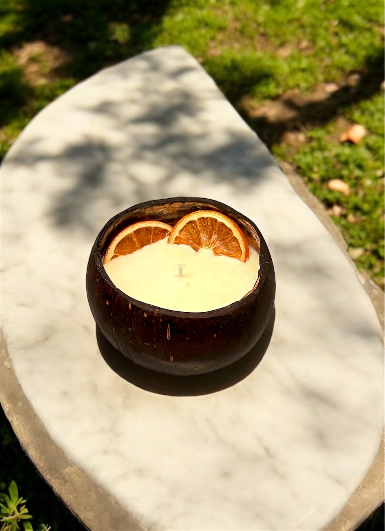 ORANGE Scented Coco shell candle with wooden slice and bottle of matches.