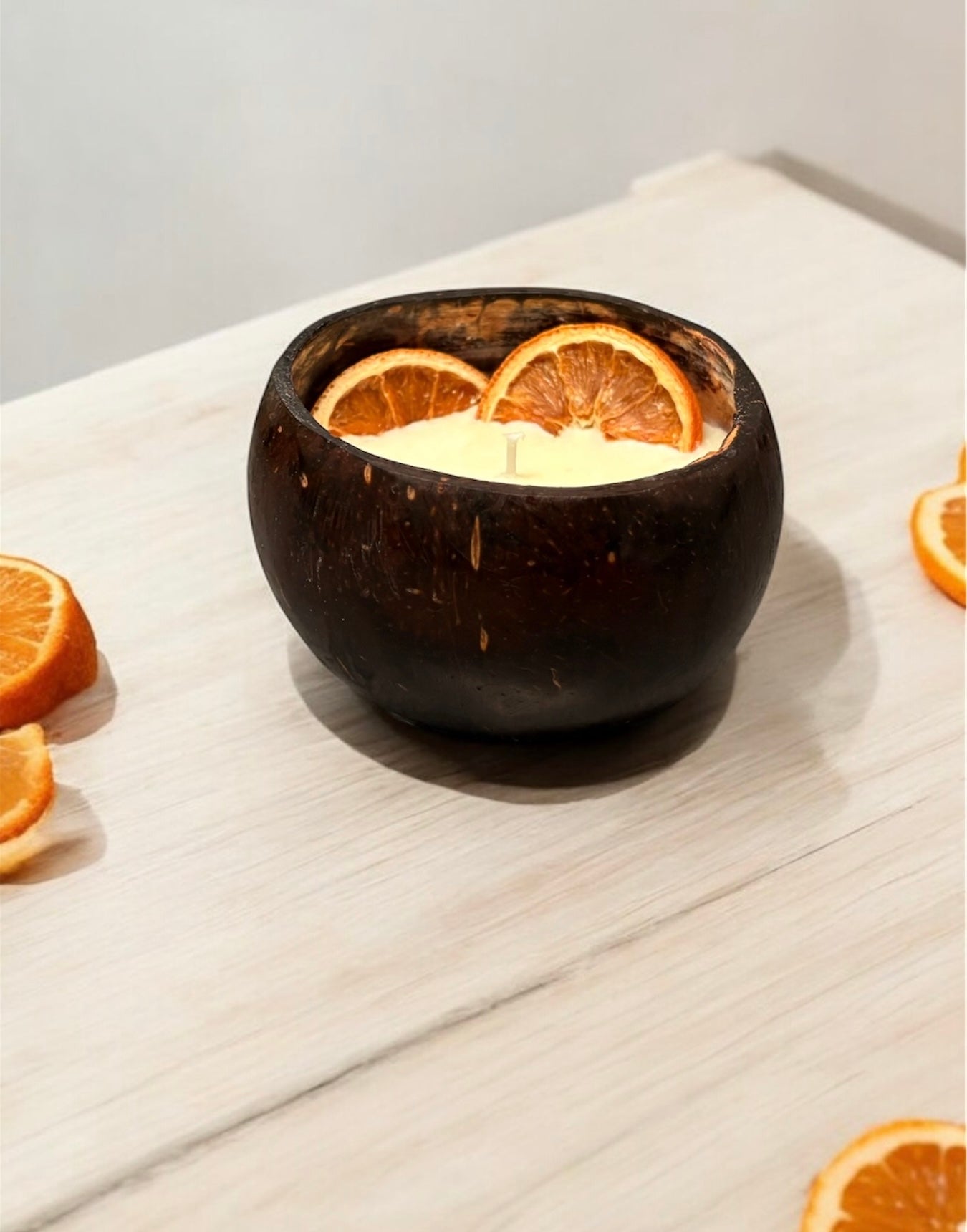 ORANGE Scented Coco shell candle with wooden slice and bottle of matches.