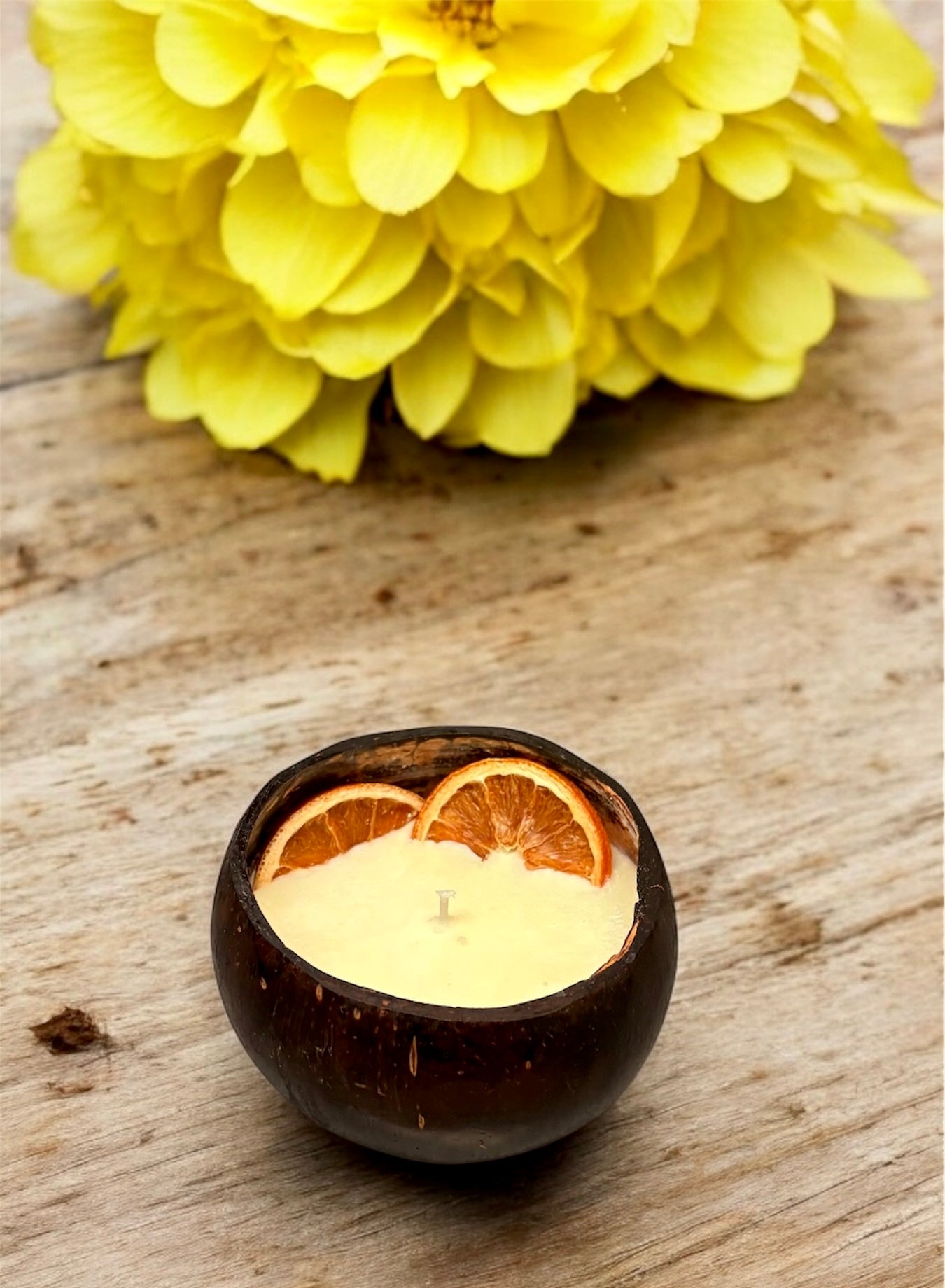 ORANGE Scented Coco shell candle with wooden slice and bottle of matches.